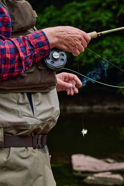 ; a fly fisherman enjoys the evening bite and a fine cigar. 